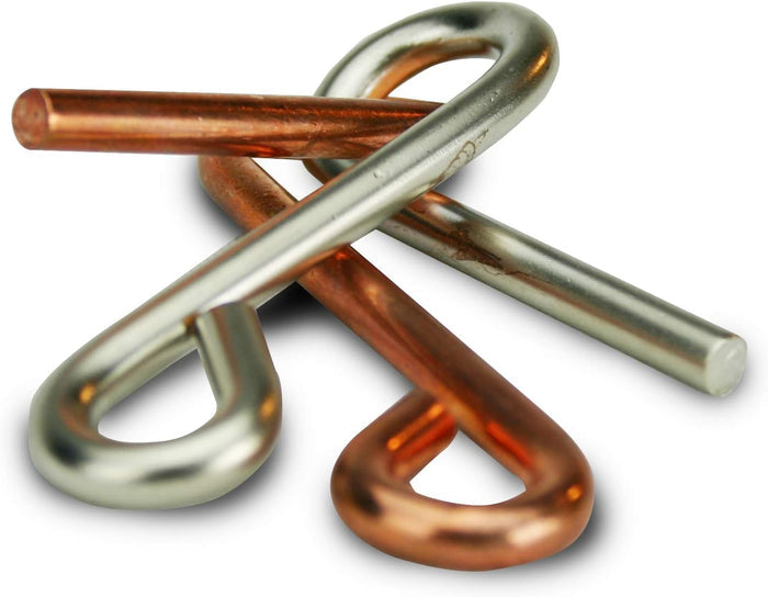 Silver and copper-colored metal wire puzzle pieces intertwined in a complex loop and bar formation.