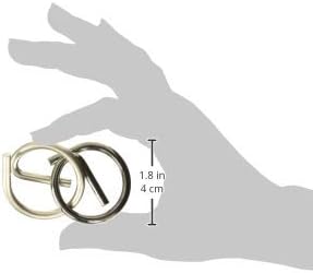 Interlocking silver and dark metal pieces of a Yin Yang puzzle held between fingers with size markings.