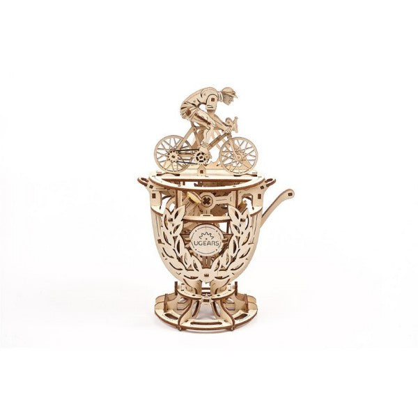 Light wood mechanical model of a cyclist on a trophy base with visible gears and laurel wreaths on a white background.