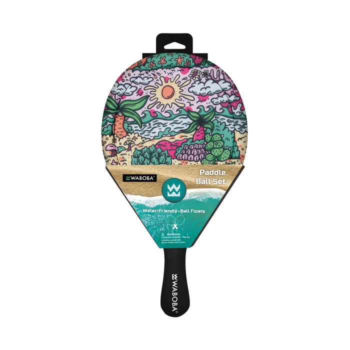 Colorful tropical-themed paddle ball set with sun and palm tree illustrations, teal packaging, and a black handle.