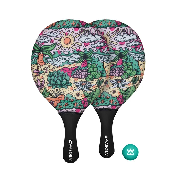 Two beach paddles with a colorful tropical sun and palm tree pattern and black handles, plus a small teal ball.
