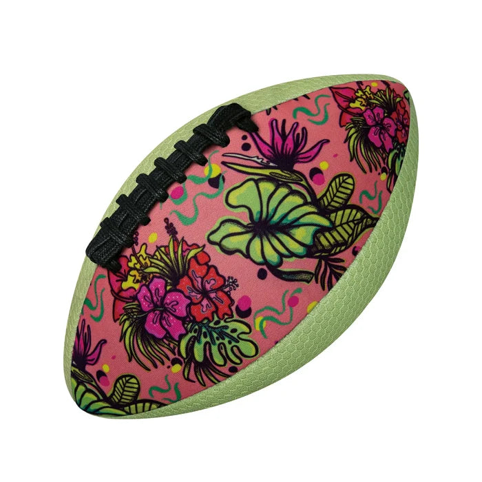 Pink American football featuring a tropical floral pattern, black laces, and light green textured grip panels.