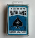 Blue and white waterproof playing cards in a clear case with ocean wave graphics and a black spade starburst logo.