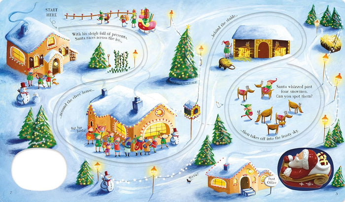 Wind-up Santa toy in a red sleigh on an illustrated book page featuring a track winding through a snowy village scene.