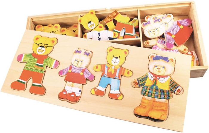 Four dressed wooden bears in a puzzle tray with extra mix-and-match pieces in a partitioned storage box behind.