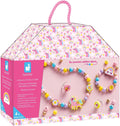 Pink unicorn house box showing a wooden bead necklace, bracelet, and rings with rainbow and unicorn charms.