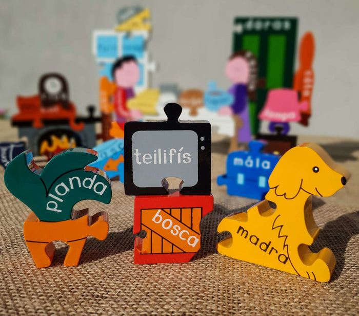 Colorful wooden puzzle pieces featuring a yellow dog and Irish words like teilifís, madra, and bosca on burlap.